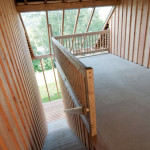 Chalupy k pronájmu na Šumavě - krytý prostor (veranda) slouží k posezení a odděluje zvukově i stavevně oba apartmány. Díky prosklené střeše nabízí výhled do údolí řeky Otavy.